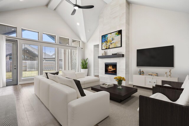 24515 Green Buffalograss Trl, Katy, TX 77493 - living area featuring a ceiling fan, high vaulted ceiling, a fireplace, wood finished floors, and beam ceiling