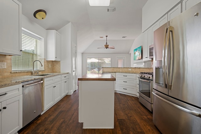 20711 Medallion Pointe Dr, Katy, TX 77450 - kitchen with stainless steel appliances, a sink, decorative backsplash, white cabinetry, and lofted ceiling
