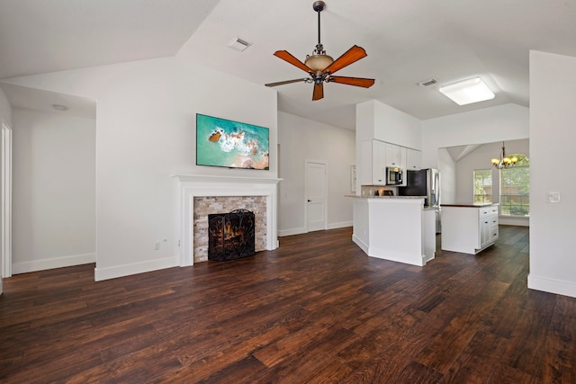 20711 Medallion Pointe Dr, Katy, TX 77450 - unfurnished living room featuring lofted ceiling, a chandelier, a stone fireplace, ceiling fan, and dark wood-style flooring