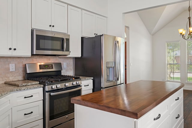 20711 Medallion Pointe Dr, Katy, TX 77450 - kitchen featuring appliances with stainless steel finishes, butcher block countertops, decorative backsplash, lofted ceiling, and white cabinets