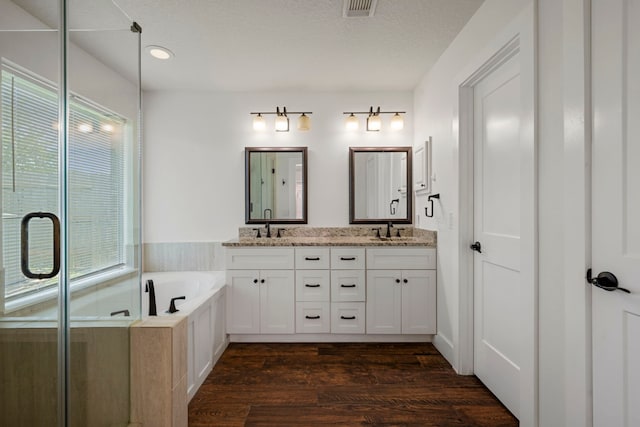 20711 Medallion Pointe Dr, Katy, TX 77450 - bathroom with healthy amount of natural light, a bath, double vanity, wood finished floors, and recessed lighting