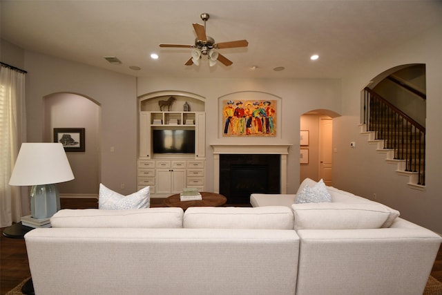 21006 Refuge Creek Dr, Cypress, TX 77433 - living room with ceiling fan, dark wood-type flooring, a fireplace, arched walkways, and recessed lighting