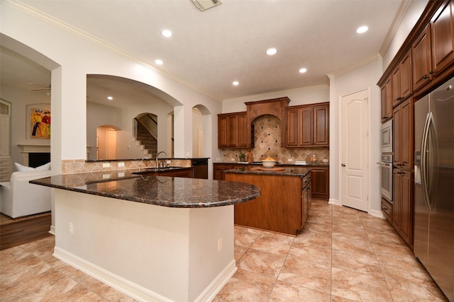 21006 Refuge Creek Dr, Cypress, TX 77433 - kitchen with appliances with stainless steel finishes, a kitchen island, backsplash, ornamental molding, and recessed lighting