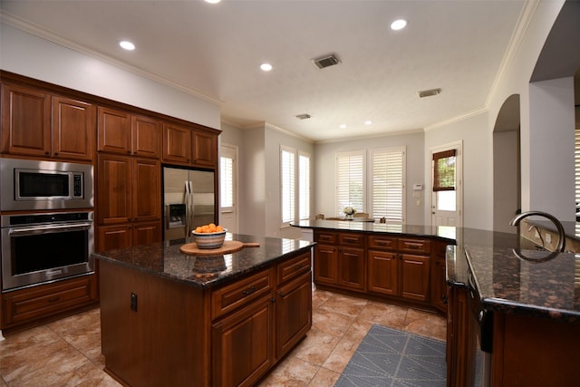 21006 Refuge Creek Dr, Cypress, TX 77433 - kitchen featuring stainless steel appliances, a center island, recessed lighting, crown molding, and dark stone counters