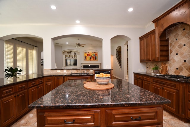 21006 Refuge Creek Dr, Cypress, TX 77433 - kitchen with stainless steel gas cooktop, a ceiling fan, backsplash, open floor plan, and crown molding