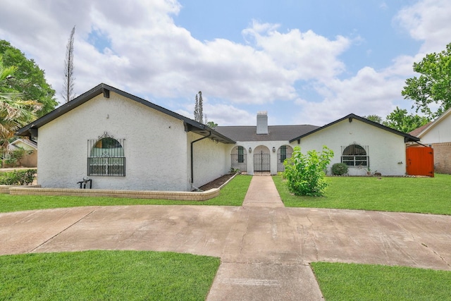 6003 Green Falls Dr, Houston, TX 77088 - view of front facade featuring a chimney, stucco siding, and a gate