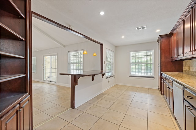 6003 Green Falls Dr, Houston, TX 77088 - kitchen featuring a breakfast bar area, light tile patterned floors, stainless steel dishwasher, plenty of natural light, and recessed lighting