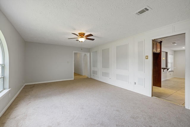 6003 Green Falls Dr, Houston, TX 77088 - spare room with light carpet, ceiling fan, a textured ceiling, and baseboards
