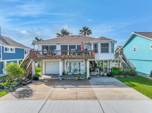 1309 Blue Heron St, Bayou Vista, TX 77563 - view of front of home with stairs, concrete driveway, a garage, a deck, and a shingled roof