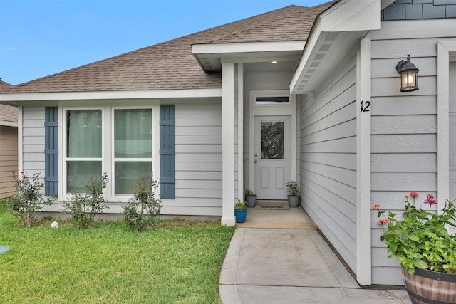12 Oakland Ct, Huntsville, TX 77340 - view of exterior entry featuring a shingled roof and a lawn