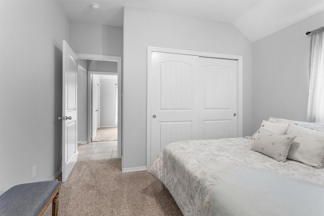 12 Oakland Ct, Huntsville, TX 77340 - bedroom featuring light carpet, a closet, lofted ceiling, baseboards, and light tile patterned floors
