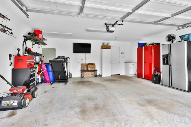 12 Oakland Ct, Huntsville, TX 77340 - garage with stainless steel fridge with ice dispenser and a garage door opener