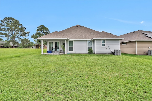 12 Oakland Ct, Huntsville, TX 77340 - rear view of property featuring central air condition unit, a yard, a shingled roof, and a sunroom