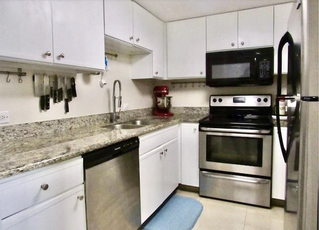 2016 Main St Unit 1505, Houston, TX 77002 - kitchen featuring appliances with stainless steel finishes, a sink, white cabinetry, light stone countertops, and light tile patterned floors