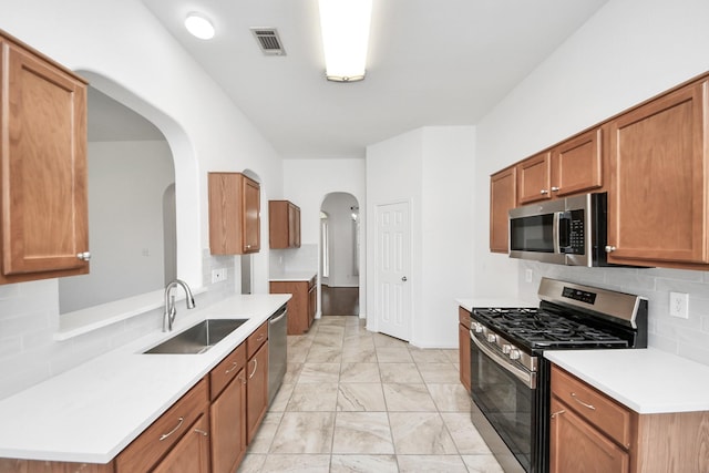 19130 Center Park Dr, Spring, TX 77373 - kitchen with stainless steel appliances, a sink, arched walkways, light marble finish floors, and backsplash