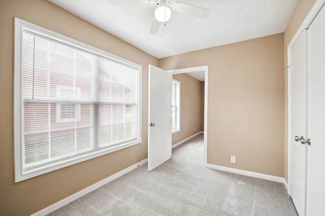 1904 Kansas St, Baytown, TX 77520 - unfurnished bedroom featuring a closet, baseboards, light colored carpet, a textured ceiling, and ceiling fan