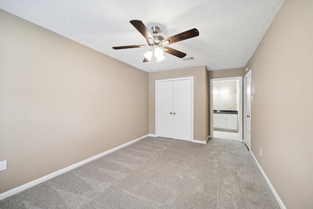 1904 Kansas St, Baytown, TX 77520 - unfurnished bedroom with light colored carpet, baseboards, a closet, a textured ceiling, and ceiling fan