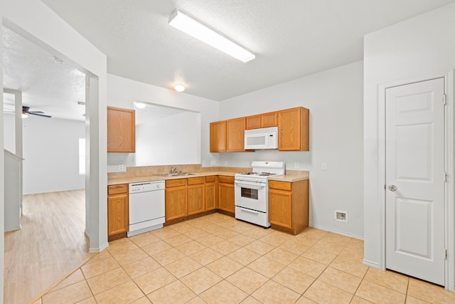 23831 Single Oak St, Spring, TX 77373 - kitchen with white appliances, a sink, light countertops, a textured ceiling, and a ceiling fan
