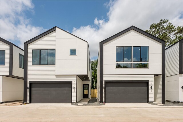 6135 Pacific Forest Dr, Houston, TX 77346 - modern home featuring an attached garage, driveway, and stucco siding