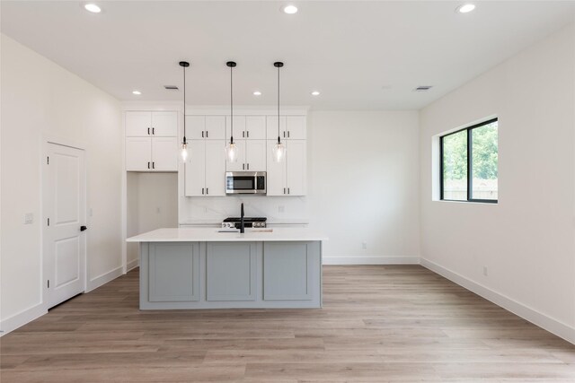 6135 Pacific Forest Dr, Houston, TX 77346 - kitchen featuring stainless steel microwave, recessed lighting, light countertops, baseboards, and white cabinets