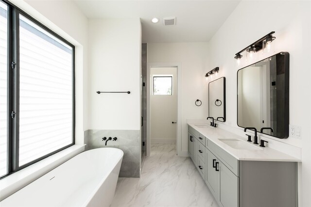 6135 Pacific Forest Dr, Houston, TX 77346 - full bathroom featuring marble finish floors, a soaking tub, double vanity, and recessed lighting