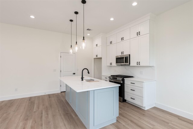 6135 Pacific Forest Dr, Houston, TX 77346 - kitchen featuring appliances with stainless steel finishes, a sink, light wood-style floors, white cabinetry, and light countertops