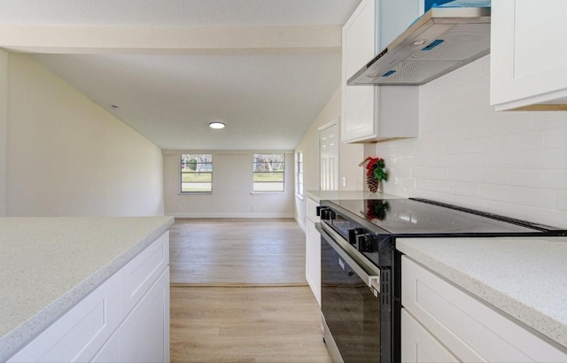 51 Blue Bonnet Ct, Lake Jackson, TX 77566 - kitchen featuring black range with electric stovetop, wall chimney range hood, light wood-style flooring, white cabinetry, and lofted ceiling