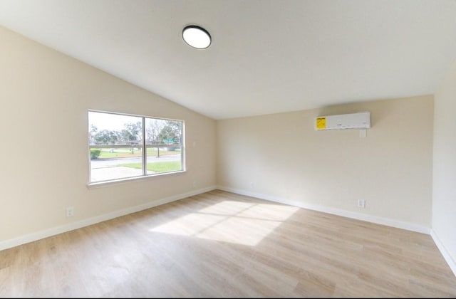 51 Blue Bonnet Ct, Lake Jackson, TX 77566 - empty room with a wall mounted air conditioner, light wood finished floors, vaulted ceiling, and baseboards
