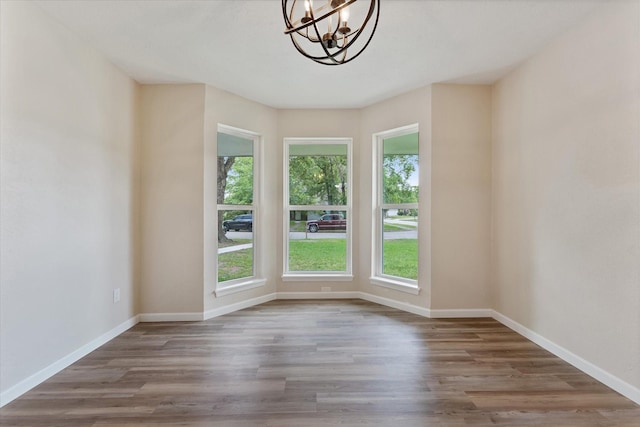 9863 Swan Ct, Conroe, TX 77385 - unfurnished room with plenty of natural light, a chandelier, and wood finished floors