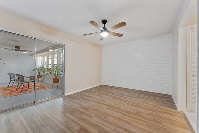 9863 Swan Ct, Conroe, TX 77385 - empty room featuring a ceiling fan, light wood finished floors, baseboards, and brick wall