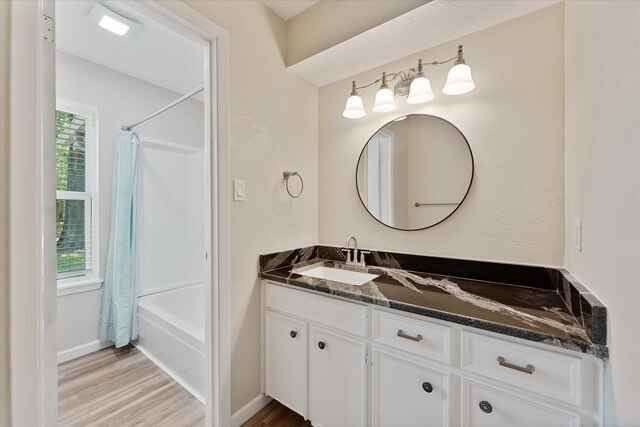 9863 Swan Ct, Conroe, TX 77385 - full bathroom featuring vanity, wood finished floors, plenty of natural light, and shower / bath combination with curtain