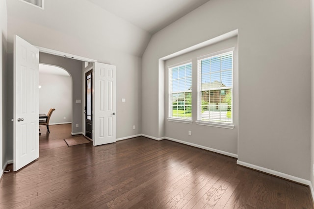 32039 Autumn Orchard Ln, Conroe, TX 77385 - unfurnished room featuring arched walkways, dark wood-type flooring, baseboards, and lofted ceiling