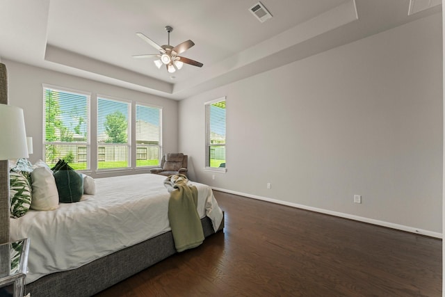 32039 Autumn Orchard Ln, Conroe, TX 77385 - bedroom with a tray ceiling, dark wood-type flooring, baseboards, and ceiling fan