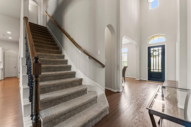 32039 Autumn Orchard Ln, Conroe, TX 77385 - entryway with arched walkways, a towering ceiling, stairs, wood finished floors, and baseboards