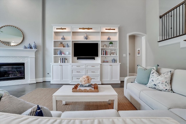 107 E Sawyer Ridge Dr, Spring, TX 77389 - living room featuring arched walkways, dark wood finished floors, baseboards, and a fireplace