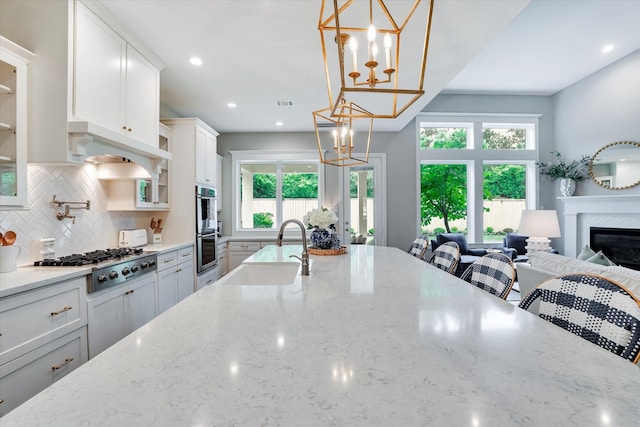 107 E Sawyer Ridge Dr, Spring, TX 77389 - kitchen with stainless steel appliances, a sink, a chandelier, tasteful backsplash, and plenty of natural light