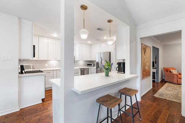 8015 Skyline Dr, Houston, TX 77063 - kitchen featuring stainless steel appliances, ornamental molding, backsplash, dark wood-style floors, and a peninsula