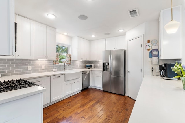 8015 Skyline Dr, Houston, TX 77063 - kitchen featuring appliances with stainless steel finishes, a sink, light countertops, white cabinetry, and dark wood finished floors