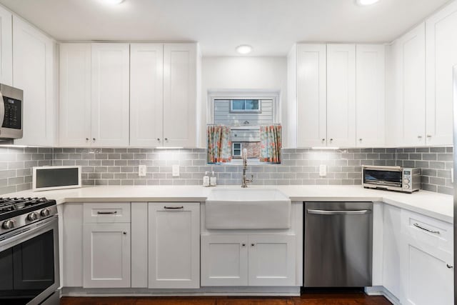 8015 Skyline Dr, Houston, TX 77063 - kitchen featuring appliances with stainless steel finishes, a sink, white cabinets, light countertops, and decorative backsplash