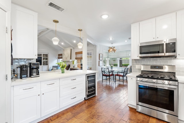 8015 Skyline Dr, Houston, TX 77063 - kitchen with appliances with stainless steel finishes, wine cooler, decorative backsplash, dark wood-style floors, and light countertops