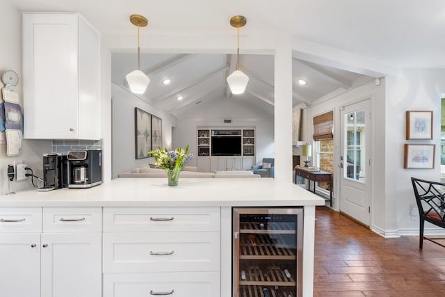 8015 Skyline Dr, Houston, TX 77063 - kitchen with wine cooler, a peninsula, white cabinetry, dark wood-style floors, and hanging light fixtures