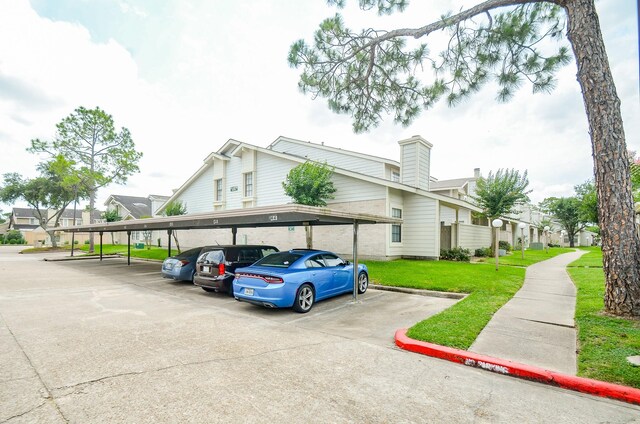 6211 Ludington Dr Unit 21-909, Houston, TX 77035 - view of front of property featuring covered parking, a front yard, a residential view, and a chimney
