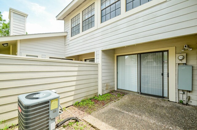 6211 Ludington Dr Unit 21-909, Houston, TX 77035 - property entrance featuring central air condition unit, a patio area, and a chimney