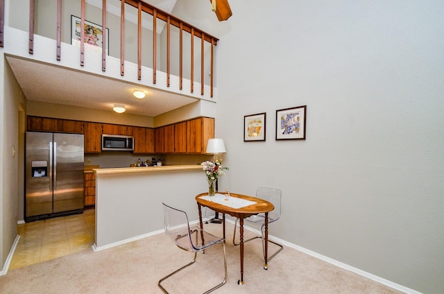 6211 Ludington Dr Unit 21-909, Houston, TX 77035 - kitchen with stainless steel appliances, light carpet, a peninsula, brown cabinets, and baseboards