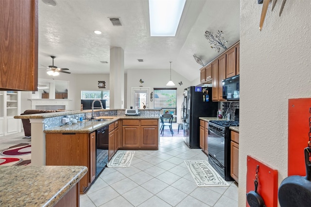 411 Ceole Ln, League City, TX 77573 - kitchen with black appliances, a textured ceiling, brown cabinets, a sink, and an island with sink