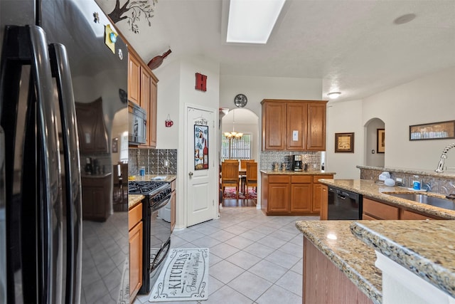 411 Ceole Ln, League City, TX 77573 - kitchen featuring black appliances, a sink, arched walkways, decorative backsplash, and light tile patterned floors
