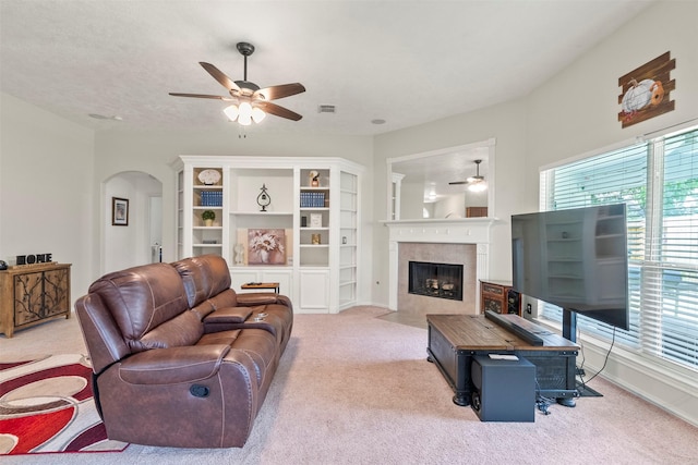 411 Ceole Ln, League City, TX 77573 - carpeted living room featuring a ceiling fan, arched walkways, and a tile fireplace