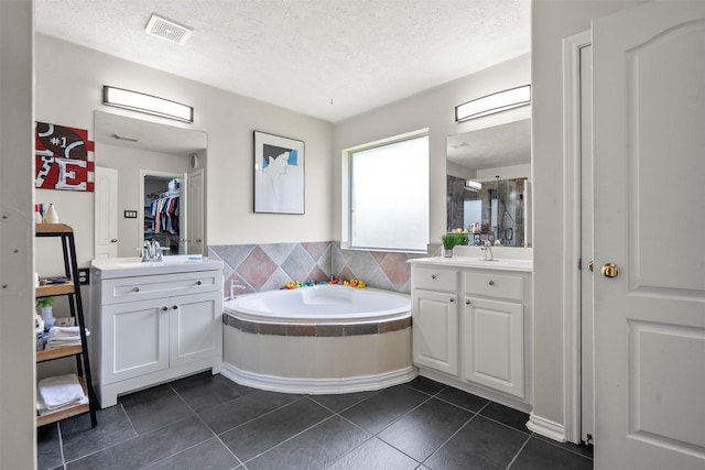 411 Ceole Ln, League City, TX 77573 - full bathroom with a textured ceiling, two vanities, a bath, tile patterned flooring, and a shower stall