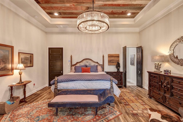 12431 Lake Vista Dr, Willis, TX 77318 - bedroom featuring a raised ceiling, crown molding, a high ceiling, a chandelier, and wood finished floors