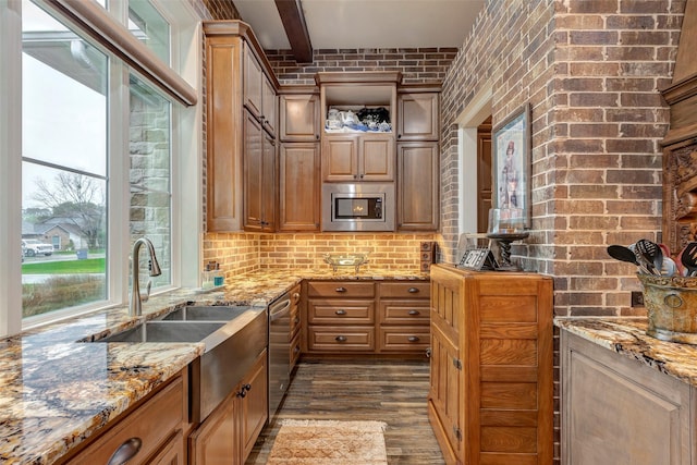 12431 Lake Vista Dr, Willis, TX 77318 - kitchen featuring stainless steel appliances, dark wood finished floors, a sink, light stone countertops, and brick wall